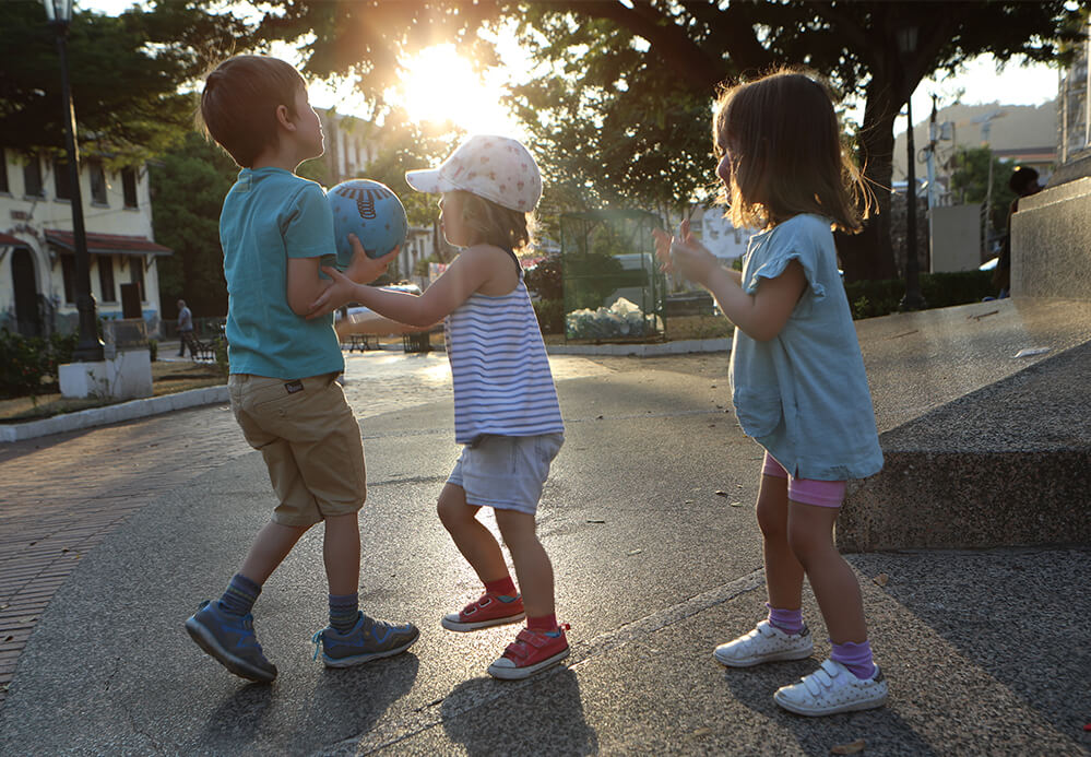 Kinder spielen mit einem Ball auf der Straße
